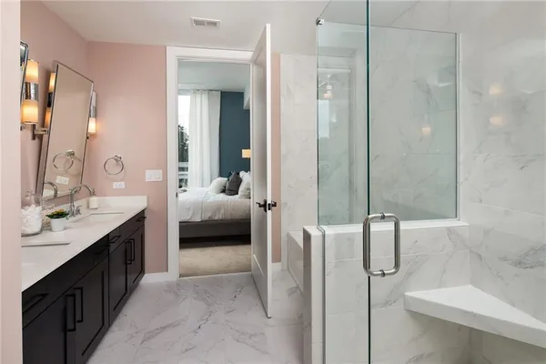 a en suite bathroom with a double vanity sink a large mirror and a shower