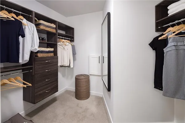 a view of walk in closet with clothes and shoes