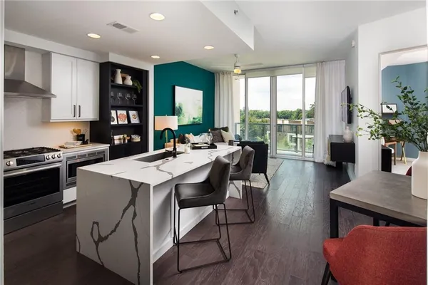 a kitchen that has a table chairs stainless steel appliances and wooden floor