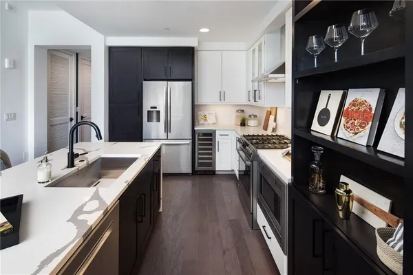 a kitchen with granite countertop stainless steel appliances cabinets a sink and a counter top space