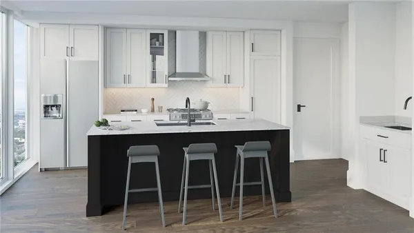 a white kitchen with a sink and chairs