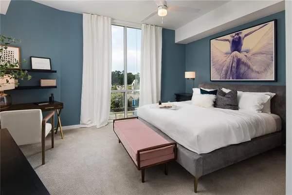 a bedroom with a bed a painting on the wall and a potted plant