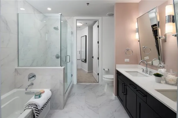 a spacious bathroom with a tub sink shower and mirror