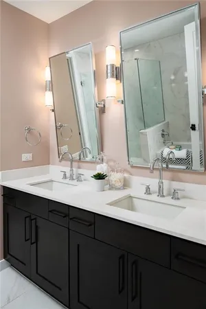 a bathroom with double vanity sinks and a mirror