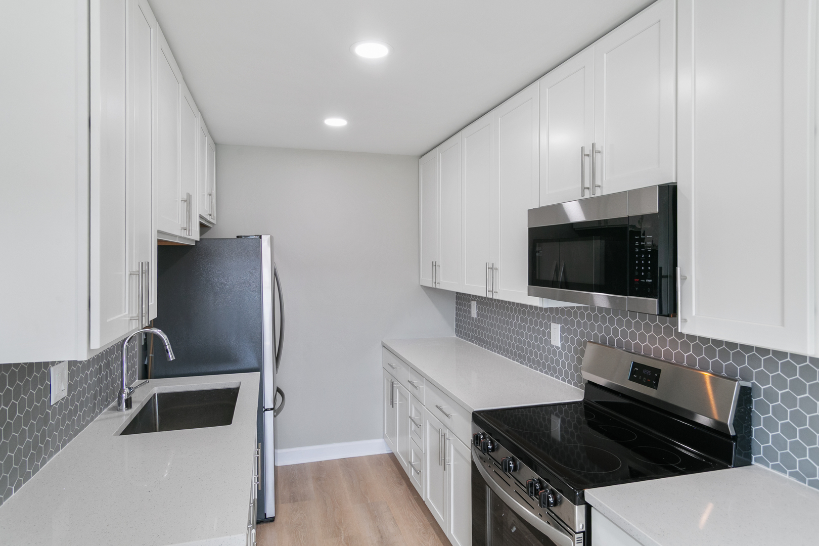 405 East Reed Street, Unit 9 Braidwood, IL 60408 - Photo 3 of 14 a kitchen with stainless steel appliances a stove a microwave and a sink