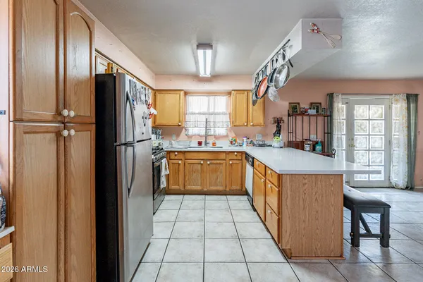 a kitchen with a sink dishwasher a stove and white cabinets with wooden floor
