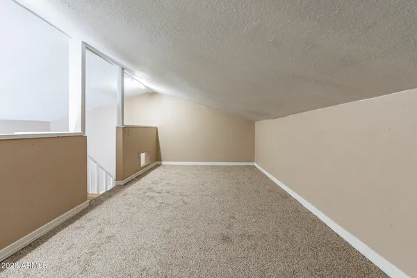 a view of an empty room with a window and a workspace