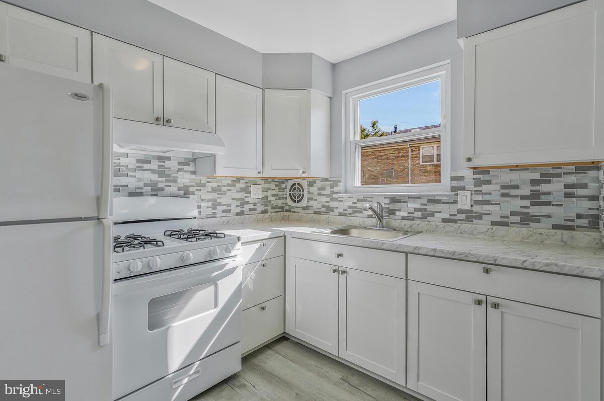 1879 Addison Road South District Heights, MD 20747 - Photo 8 of 27 a kitchen with granite countertop white cabinets and white appliances