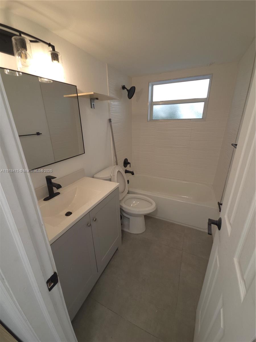 467 Golden Isles Drive, Unit 110 Hallandale Beach, FL 33009 - Photo 7 of 11 a bathroom with a sink a toilet and shower