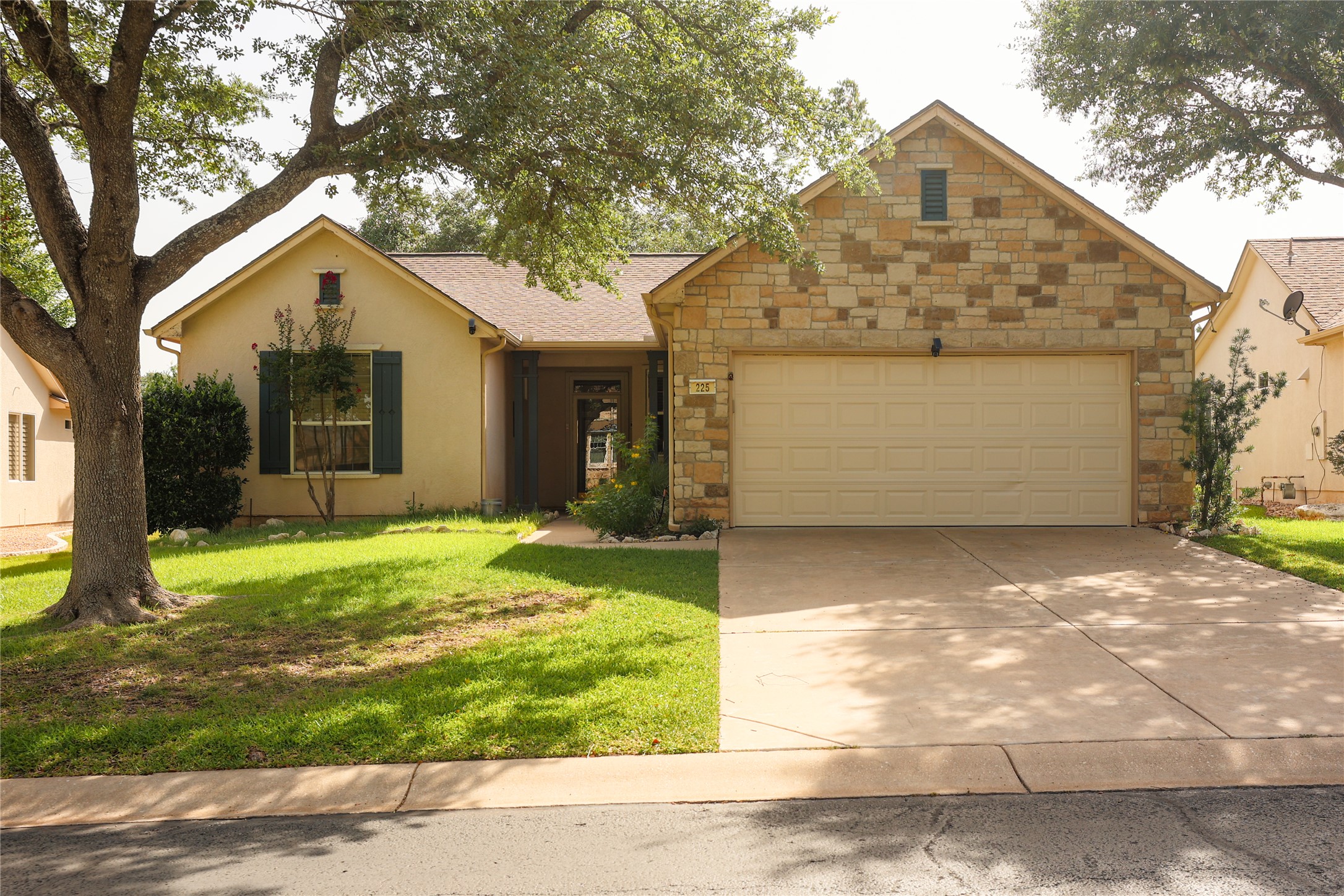 Features an attached garage and a charming stone and stucco exterior.
