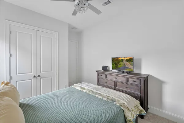 a view of a livingroom with wooden floor and a ceiling fan