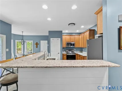 a kitchen with granite countertop a sink a stove and cabinets