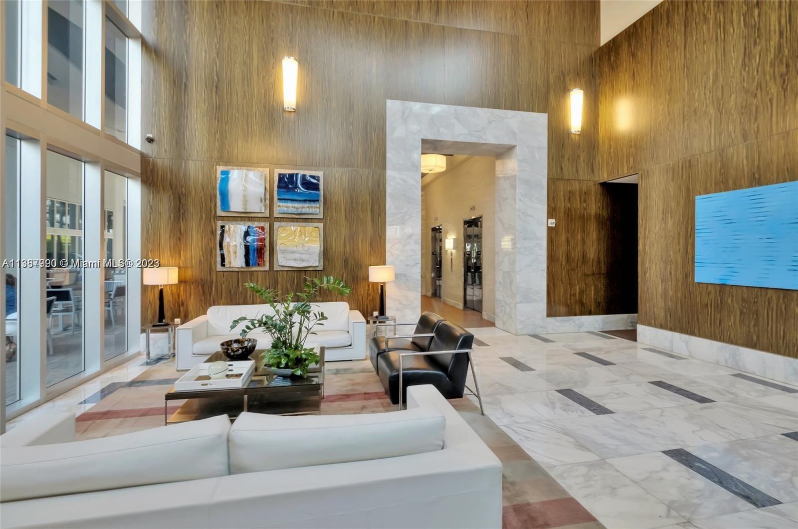 185 Southwest 7th Street, Unit 2204 Miami, FL 33130 - Photo 16 of 29 a living room with furniture and a chandelier