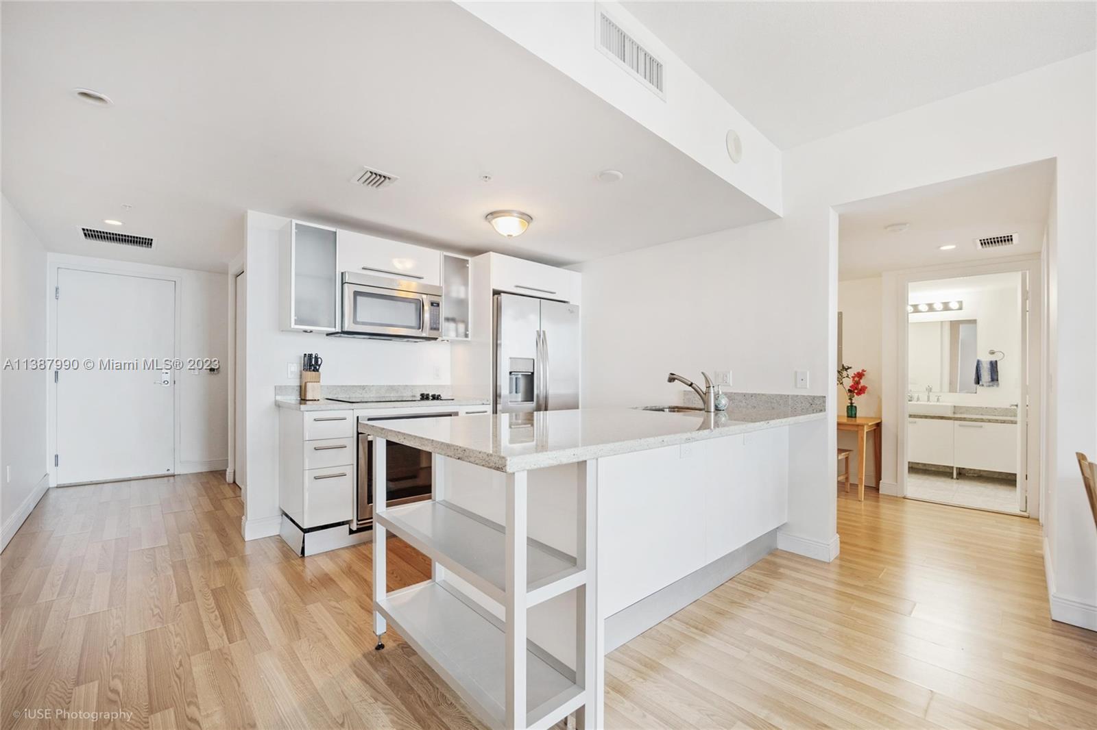 185 Southwest 7th Street, Unit 2204 Miami, FL 33130 - Photo 6 of 29 a view of a kitchen with wooden floor and electronic appliances