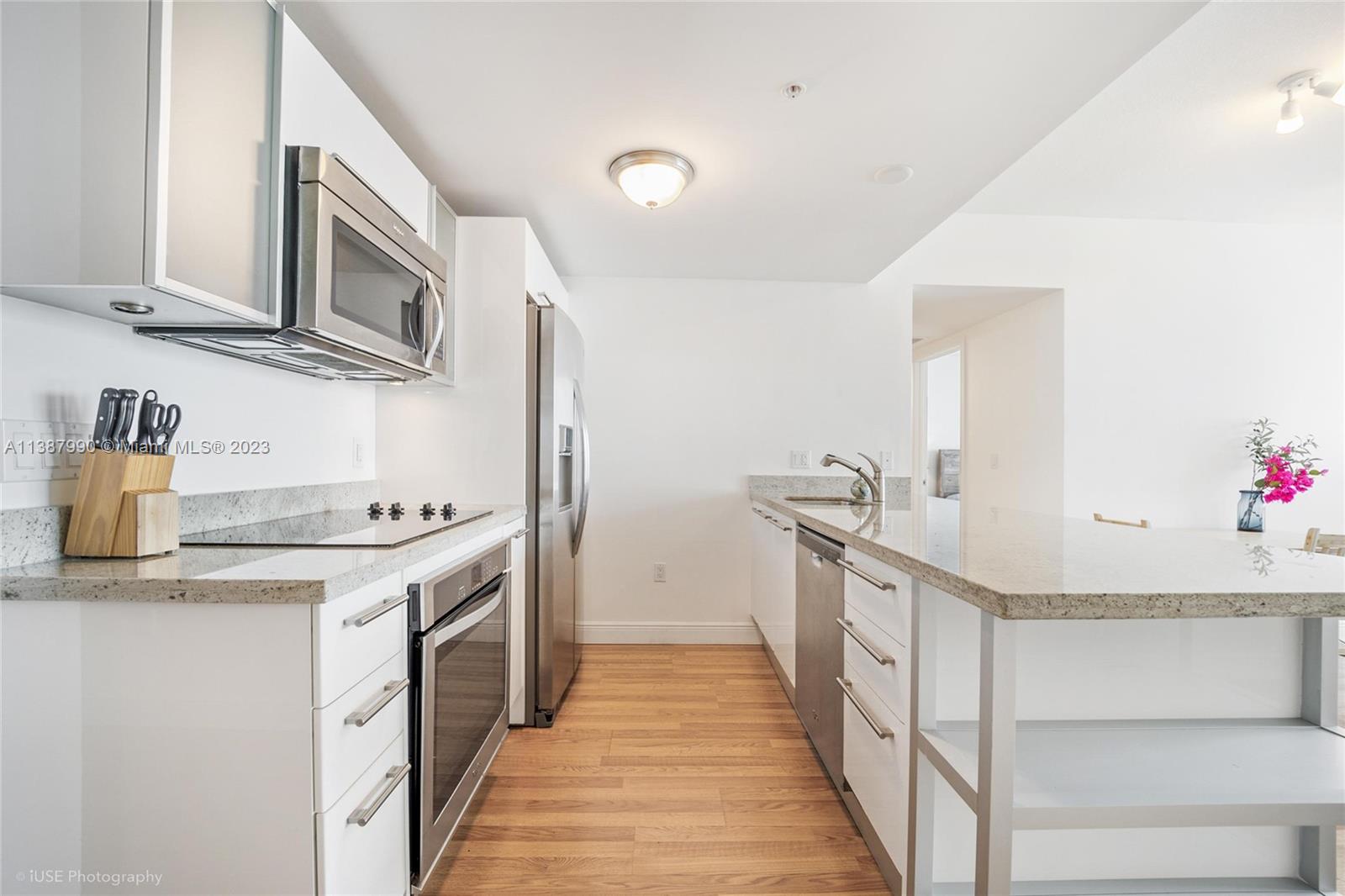 185 Southwest 7th Street, Unit 2204 Miami, FL 33130 - Photo 7 of 29 a kitchen with stainless steel appliances granite countertop a stove and a sink