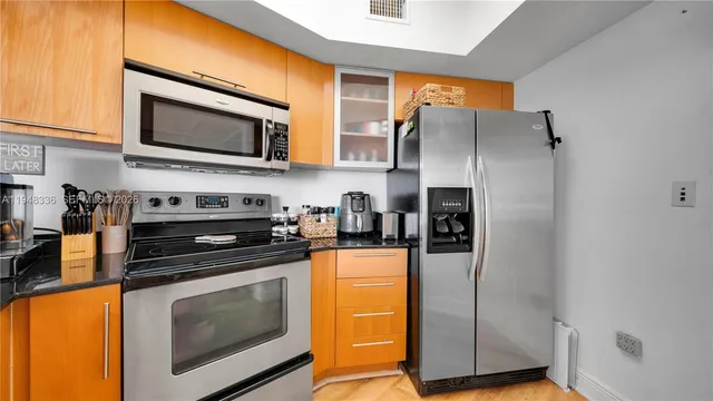a kitchen with stainless steel appliances a stove microwave and refrigerator