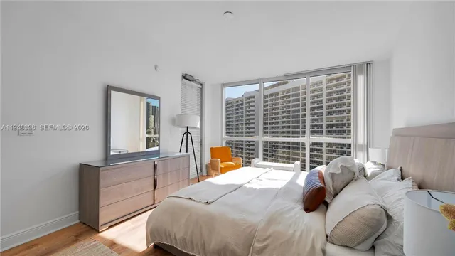 a bedroom with a bed and a large window