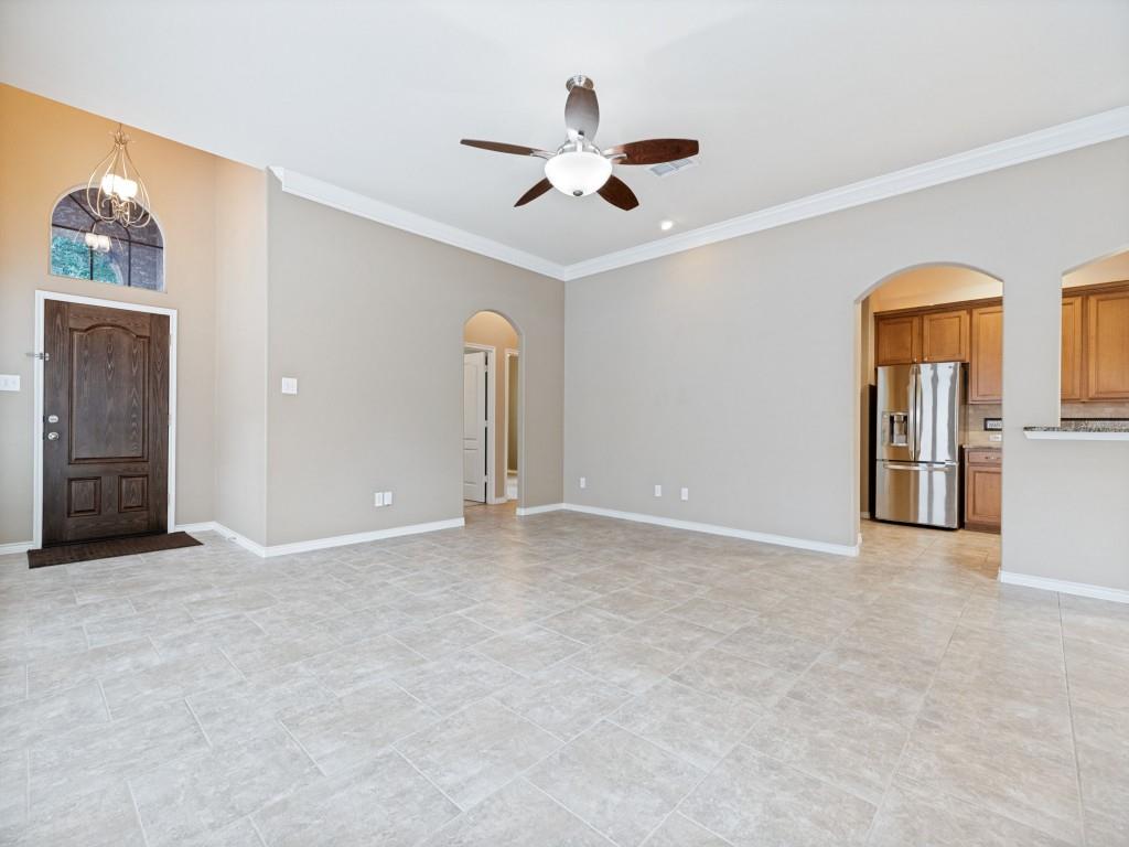 10032 Bell Rock Road Frisco, TX 75035 - Photo 5 of 23 Expansive tiled living space with arched doorways and crown molding.