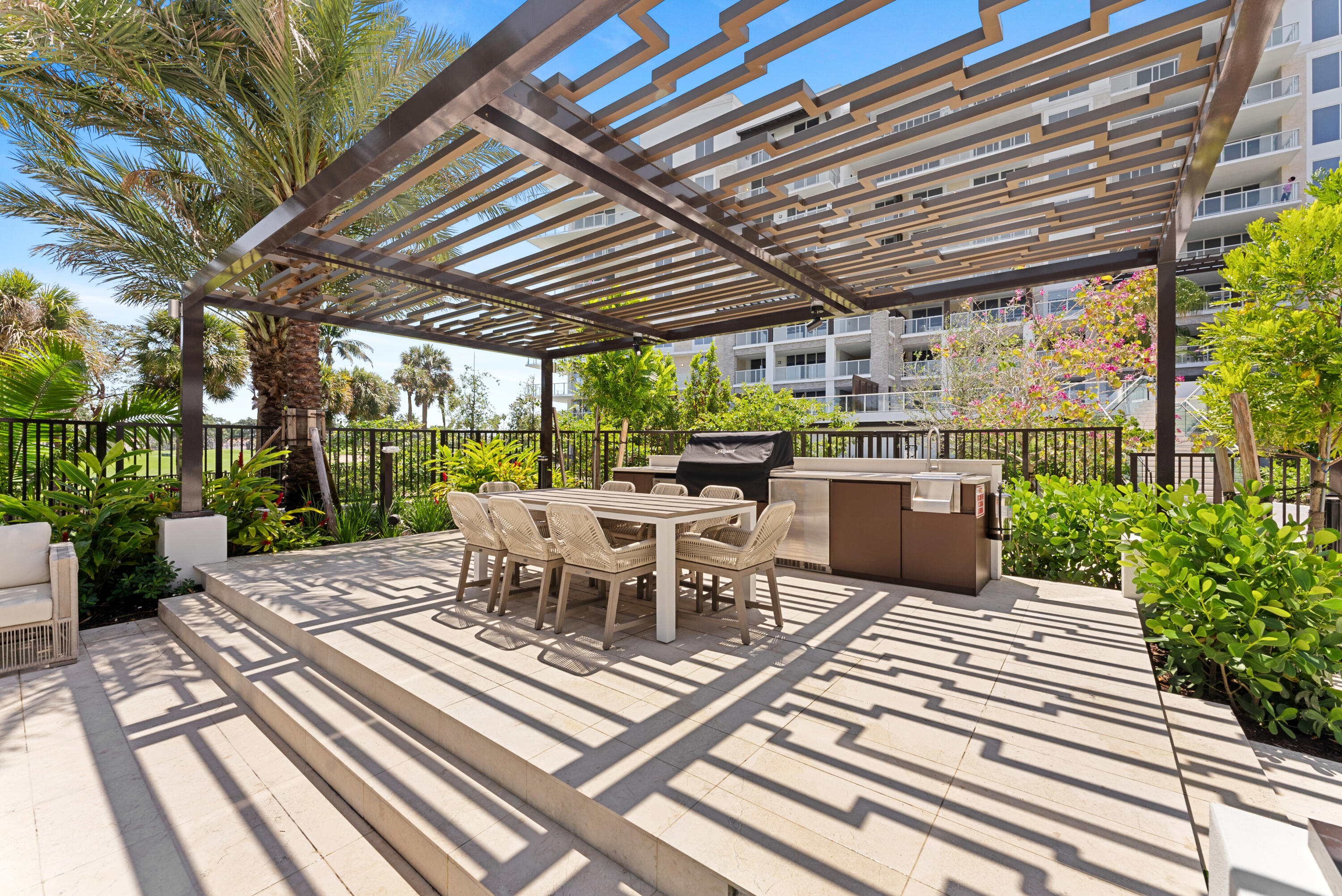 210 Southeast Mizner Boulevard, Unit 301 Boca Raton, FL 33432 - Photo 31 of 66 a view of a patio with a dining table and chairs with a wooden floor