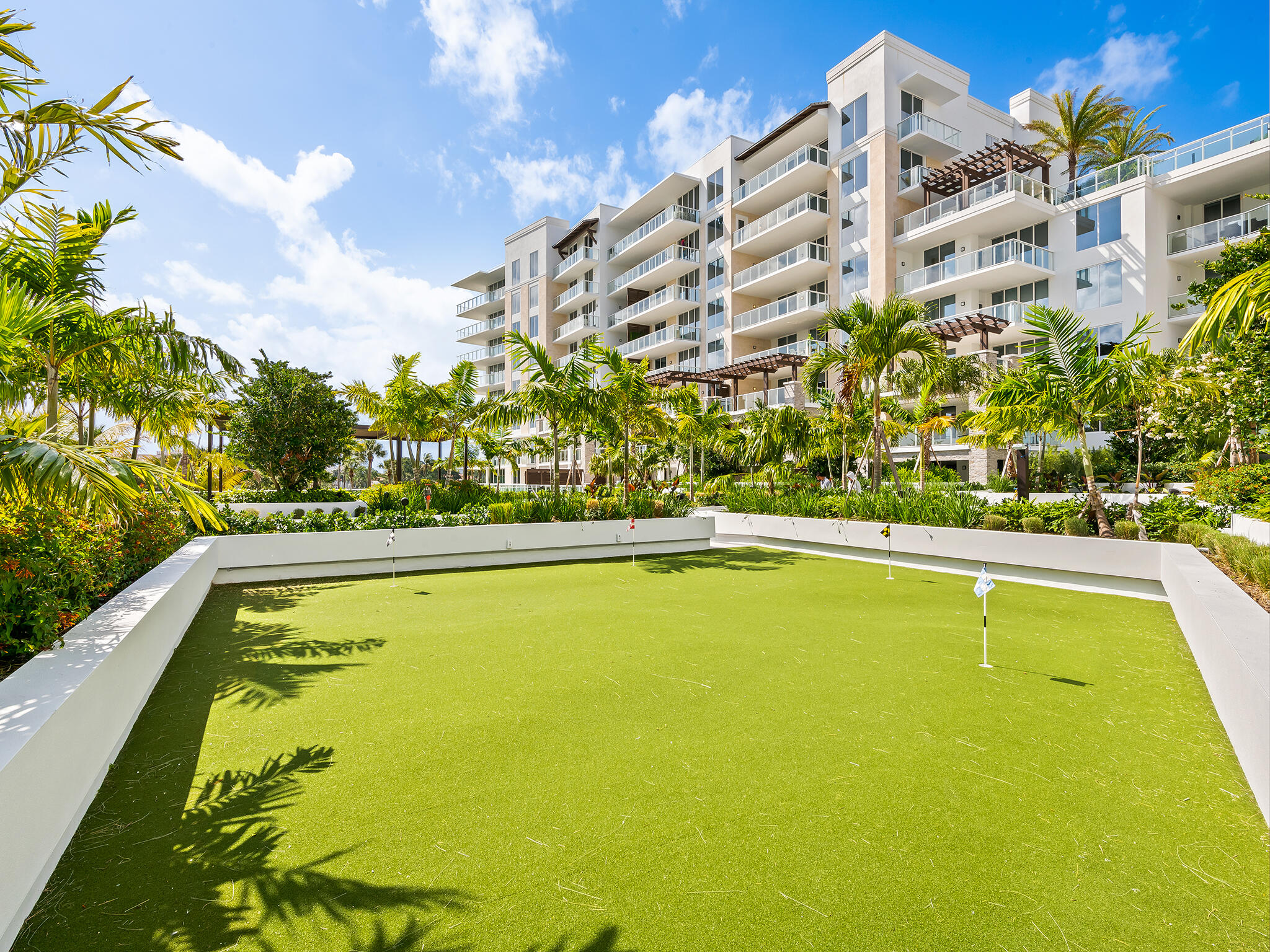 210 Southeast Mizner Boulevard, Unit 301 Boca Raton, FL 33432 - Photo 42 of 66 a view of a swimming pool with a lawn chairs under an umbrella