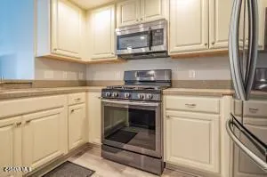 a kitchen with granite countertop a stove sink and cabinets