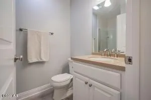 a bathroom with a toilet sink vanity and mirror