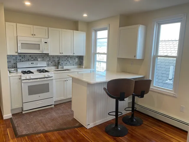 a kitchen with a stove a sink and a window