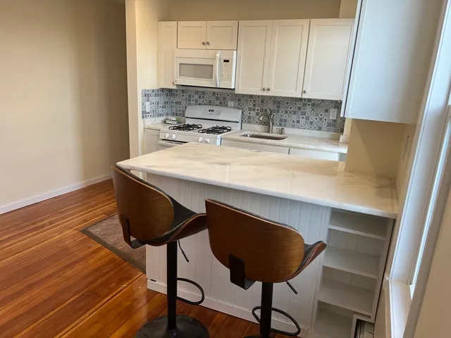 a kitchen with a sink cabinets and wooden floor
