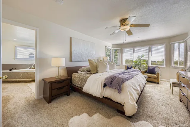 a spacious bedroom with a bed couch and window