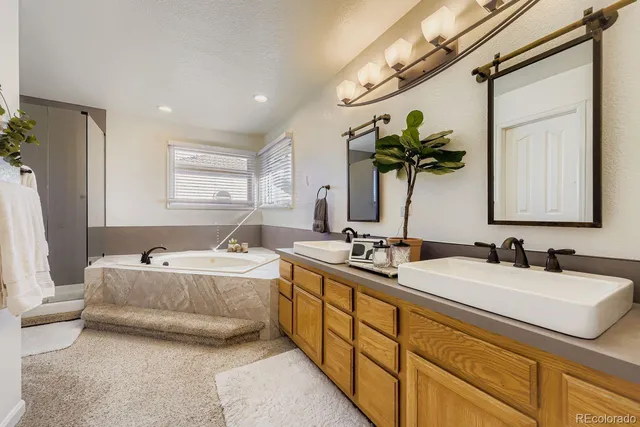 a bathroom with 2 sink tub and a mirror