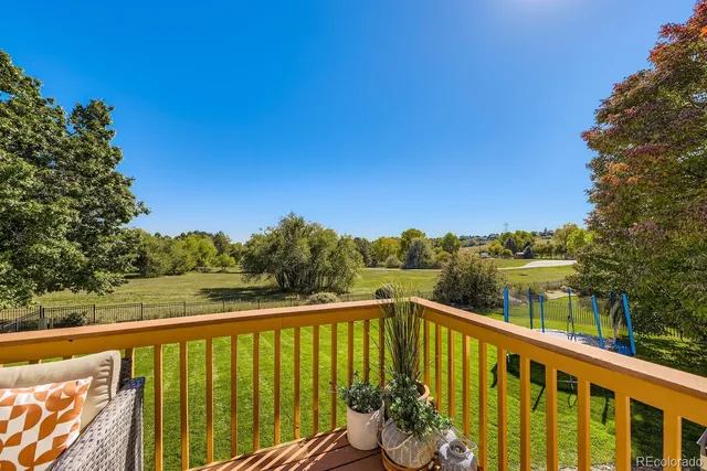 a view of a balcony with couches and wooden fence