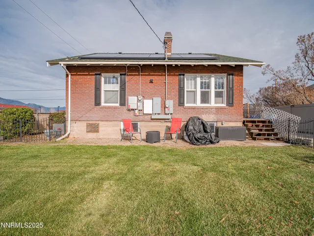 a backyard of a house with table and chairs