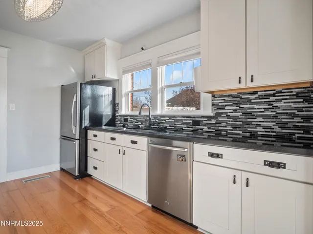 a kitchen with stainless steel appliances granite countertop a sink a stove and refrigerator