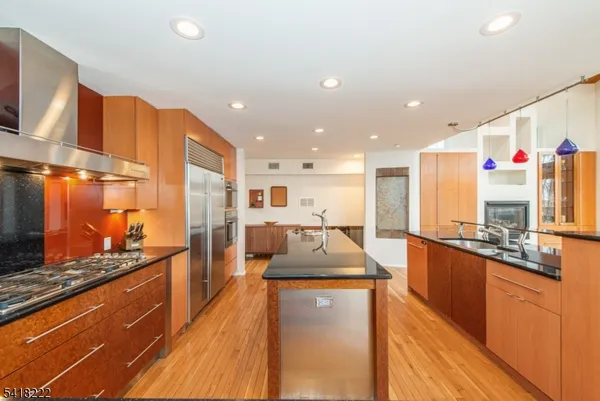 a kitchen with stainless steel appliances kitchen island granite countertop a sink stove and refrigerator