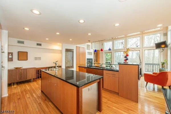 a kitchen with stainless steel appliances granite countertop a sink a stove and wooden floor
