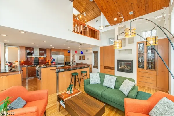 a living room with furniture a kitchen view and a chandelier