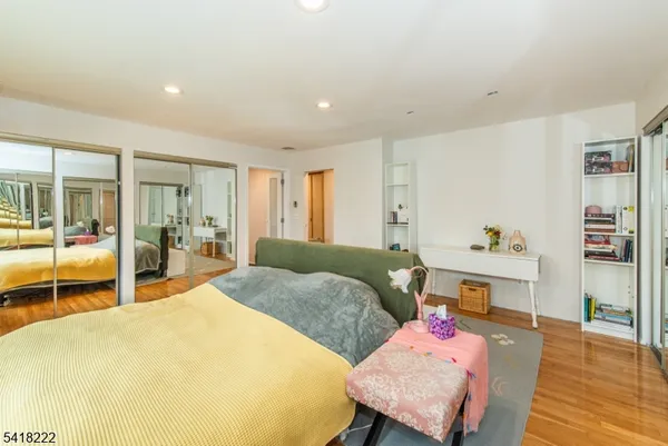a spacious bedroom with a bed and wooden floor
