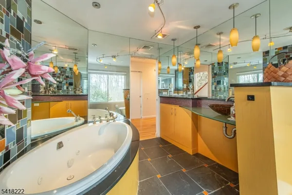 a bathroom with a tub sink and mirror