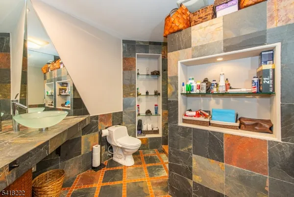 a room with granite countertop lots of clutter and stainless steel appliances