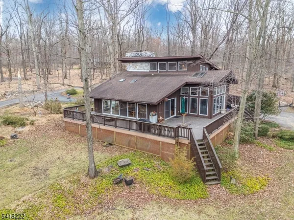 a view of a house with a yard and large tree