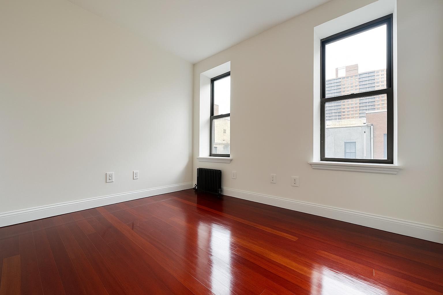 609 West 137th Street, Unit 26 Manhattan, NY 10031 - Photo 6 of 21 an empty room with wooden floor and windows