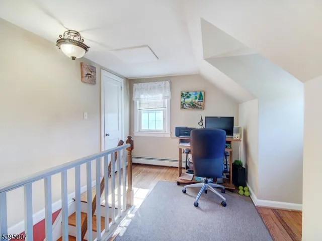 a view of a workspace with furniture and a window