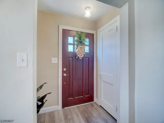 a view of a hallway with wooden floor and closet