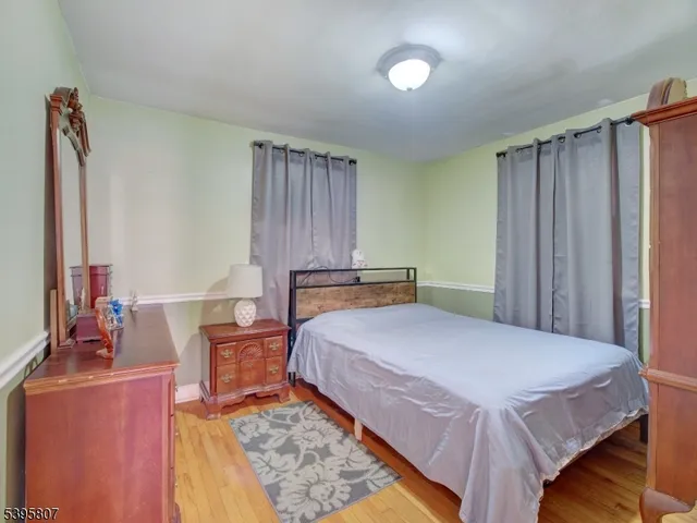 a bedroom with a bed and a dresser with mirror