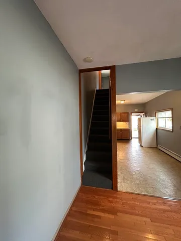 a view of a hallway with wooden floor and staircase