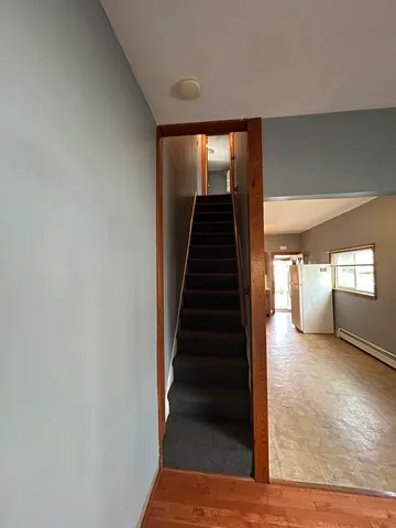 a view of a hallway with wooden floor and stairs