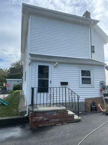 a view of a house with a small yard and wooden fence