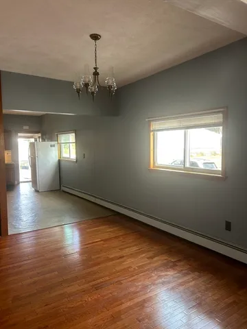 a view of wooden floor chandelier and windows in a room