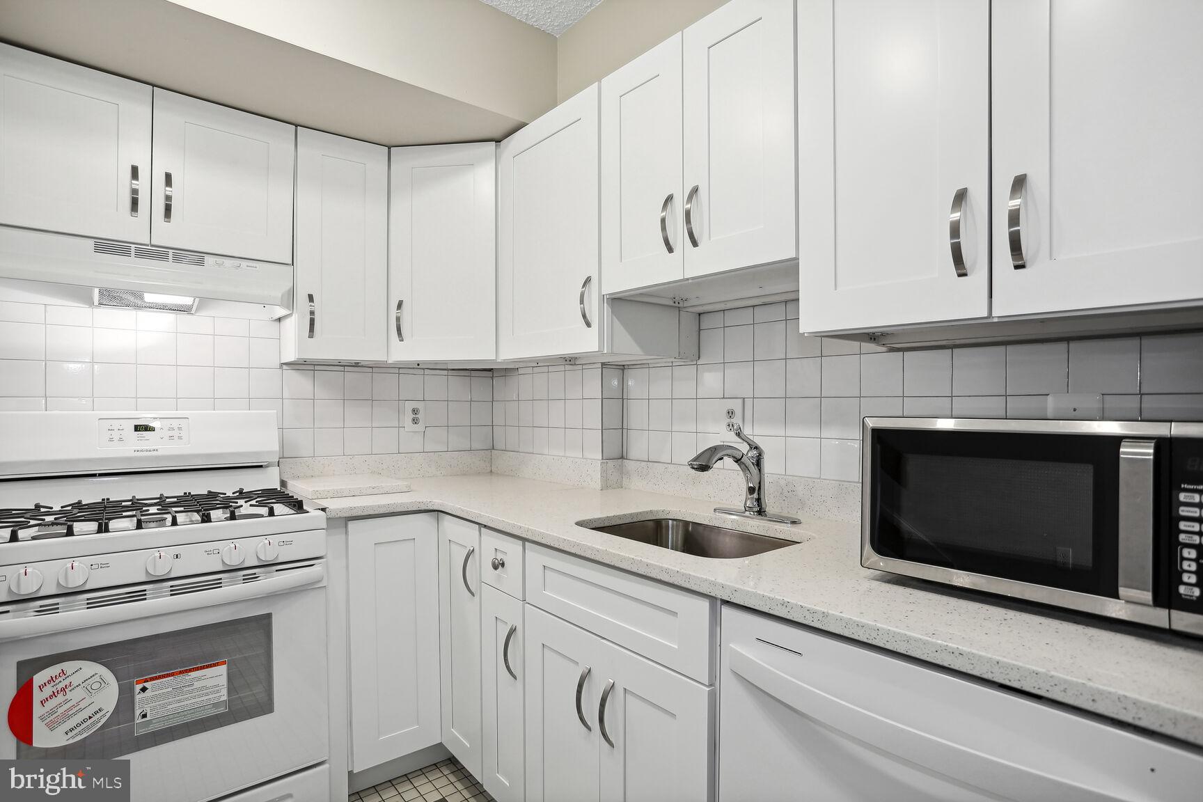 1245 13th Street Northwest, Unit 606 Washington, DC 20005 - Photo 14 of 33 a kitchen with white cabinets and appliances