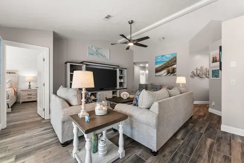 a living room with furniture a flat screen tv and a rug